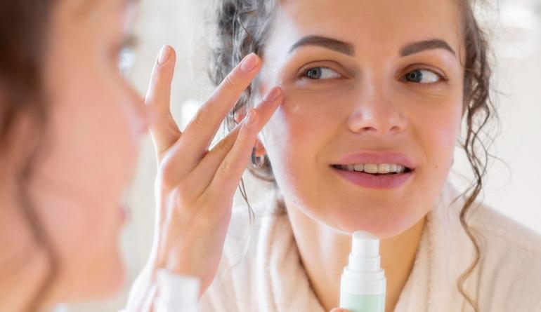 woman-applying-cream-face-while-looking-mirror.jpg